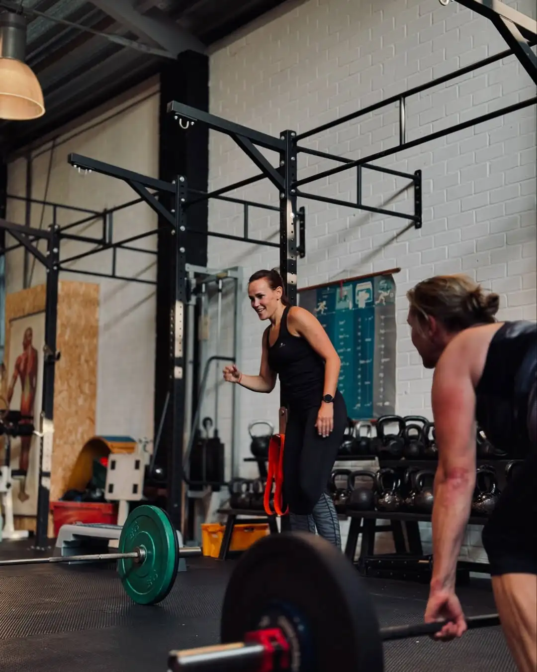 Deelnemers die binnen samen krachttraining doen met halters en materiaal